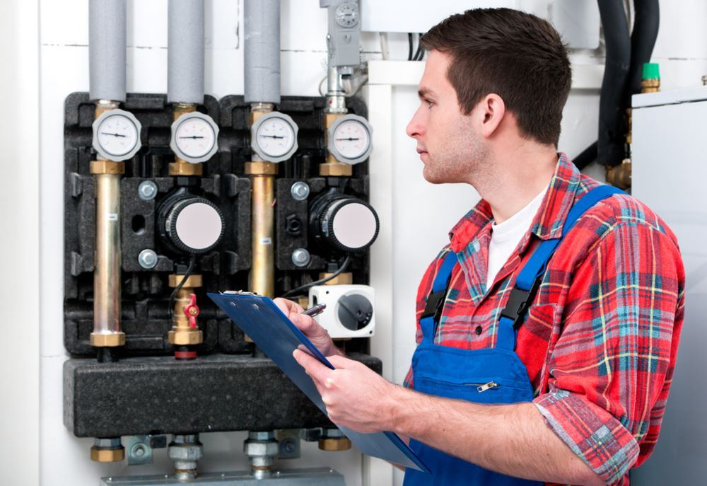 Gas Safe engineer checking plant with a clipboard